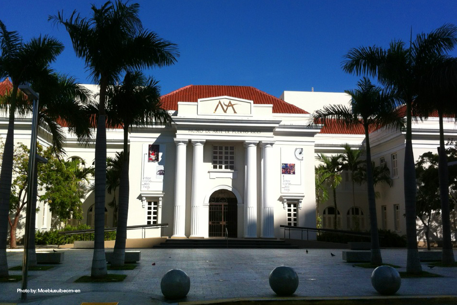 Front view of Museo de Arte of Puerto Rico surrounded by palm trees in a sunny day